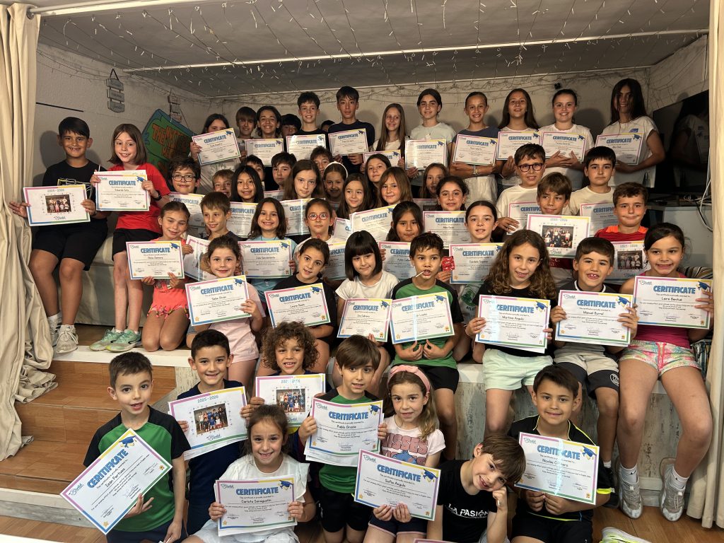 Niños de clases de inglés de mañanas en Huesca posan con sus diplomas al finalizar el curso