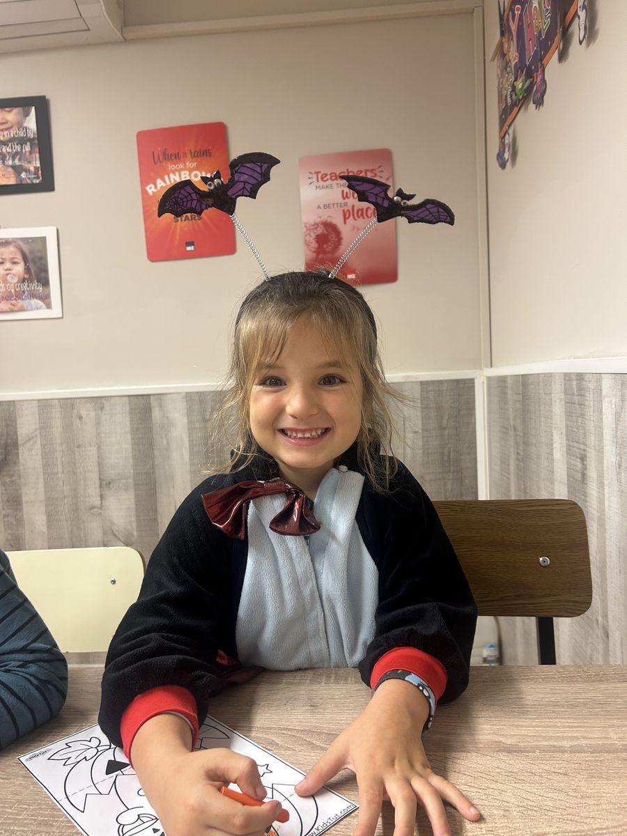 Alumna de Infantil sonriendo con diadema de murciélagos en su clase de inglés de Halloween